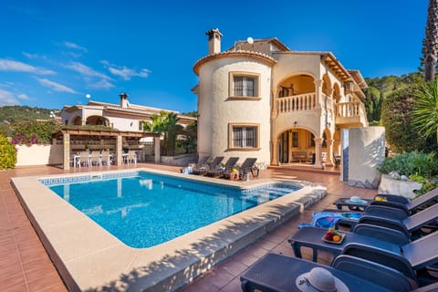 Beautiful holiday villa with private pool located in Calpe (Costa Blanca) for 14 people, with six bedrooms and three bathrooms distributed over two floors. Air conditioning in all bedrooms and central heating.FIRST FLOOR: This spacious villa is divided as follows; A spacious living room with SAT/TDT TV, access to a terrace that overlooks the outside of the house and the garden. There are 3 bedrooms, 2 of them with two twin beds (90x1.90) and the third bedroom with a double bed (1.60x1.90), an en-suite bathroom with bathtub and, in addition, a shower room with shower.GROUND FLOOR: Access by internal and external stairs. You will find a fully equipped kitchen with a gas stove, it has a porch/terrace to be able to have breakfast outdoors and be close to the pool and barbecue. On this floor there are three bedrooms. The first bedroom with two single beds (90x1.90), the second bedroom for 4 people with a double bed (1.35x1.90) and two single beds (90x1.90). The last bedroom has a double bed (1.60x1.90). There is also a shower room.EXTERIOR: Large plot with beautiful views, an 8x4 pool with 1m minimum depth and 2m maximum depth, with Roman steps and outdoor shower. It consists of a covered terrace with gas barbecue where you can enjoy good meals. There is parking on the same plot for 2/3 cars.LOCATION: The villa is located in a privileged area called "El Tossal de la Cometa", given the tranquility of the area and its proximity to the beaches and all services. It is located 3 km from the nearest supermarket, 3.5 km from the sandy beach, restaurants and 4 km from our PlusHolidays offices.OBSERVATIONS: Free Wi-Fi. Pets up to 12 kg are allowed with a supplement.