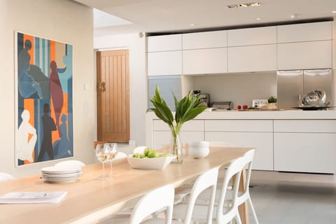 The dining area with paintings and the kitchen - Little Cottage