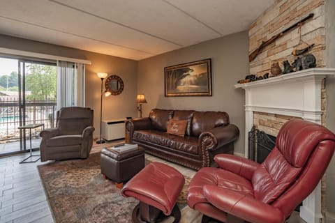 Sink into plush leather seating and feel your worries melt away in this welcoming living space, where rustic stone fireplace charm meets modern comfort—your perfect retreat after a day of adventure.