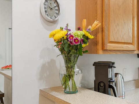 Bright and cheerful kitchen corner with coffee essentials and a fresh bouquet to brighten your stay.