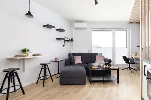 A cozy living room with a stylish couch, table, and modern lighting.
