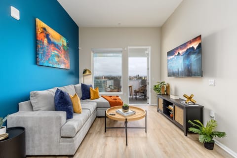 Modern living room w/ spacious layout, large windows & TV.