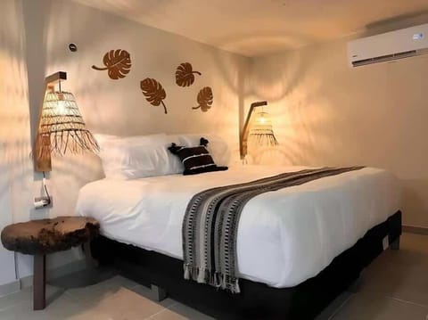 Studio sleeping area with king bed and decorative wall