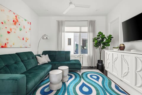 - Stylish living room with bold sofa and bright artwork   - Natural light and modern decor create a relaxing stay   - Trendy rug and smart layout enhance your vacation comfort