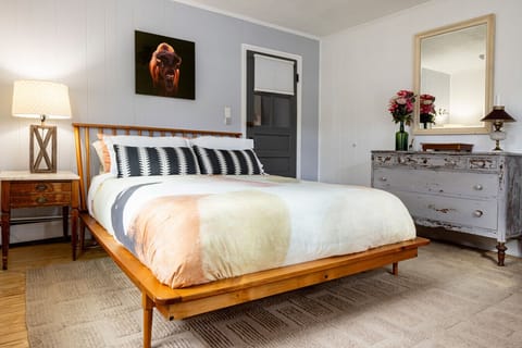 Bright and air-conditioned, the master features a bed with organic cotton bedding, feather blanket, and mattress topper, plus an antique dresser, desk, closet, and Beckerman Photography bison image from Mohawk Bison Farm.