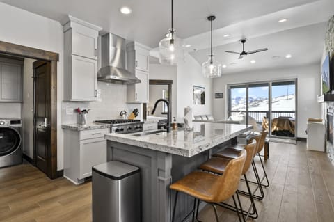 Gather in the bright and spacious chef's kitchen featuring premium appliances, a large island, and beautiful mountain views just beyond the windows.