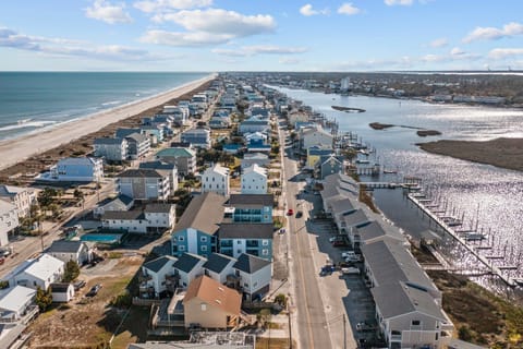 Coastal community featuring beachfront homes and marina access, positioned between ocean and bay waters.