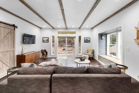 Bright and cool living area with a large couch and a view of the outside.