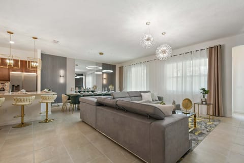 Open-concept luxury with sleek kitchen, plush seating, and designer lighting.
