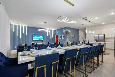 Spacious dining area with luxe seating, modern lighting, and open kitchen—perfect for gatherings!