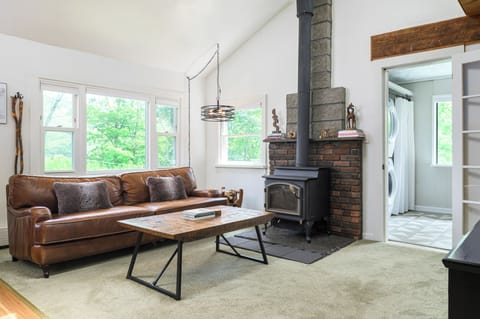 Relax and recharge in the living room with a comfy leather sofa, smart TV, and charming fireplace (please note it's decorative only).