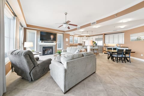 Relax in this open-concept living space with plush seating, cozy fireplace, and seamless flow to your fully equipped kitchen and dining area.
