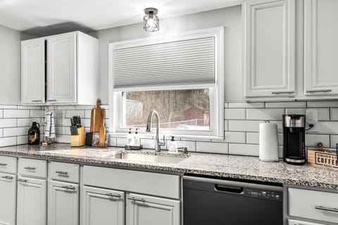 his sleek, fully equipped kitchen features granite countertops, stainless fixtures, and everything you need for home-cooked meals or morning coffee rituals