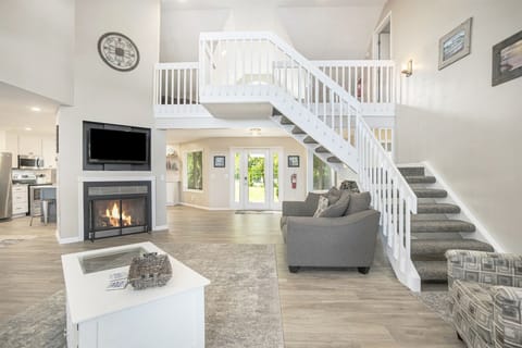 Open living room with soaring ceiling and seasonal fireplace