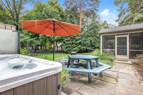 Daisy Cottage has a beautiful backyard setting with a picnic table on the patio and the relaxing hot tub