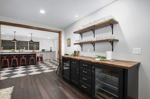 Custom wine bar has two wine/beer coolers and an assortment of glasses