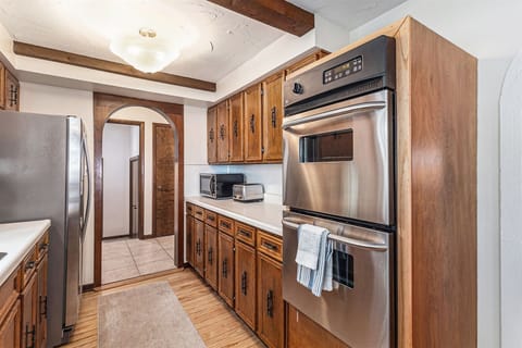The kitchen is equipped with all of the essential, including a double oven, stovetop, toaster, microwave, and spacious fridge