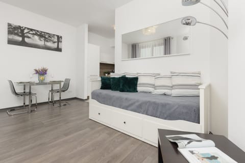 A modern living room with a gray sofa, white furniture, and a minimalist style.
