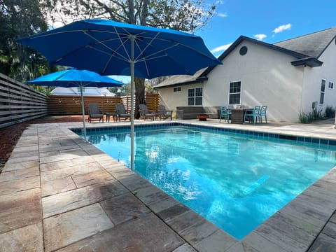 Heated Pool And Fenced Backyard - Fenced backyard with heated pool, in-water umbrellas, lounge seating, and space to unwind after beach or Village time.
