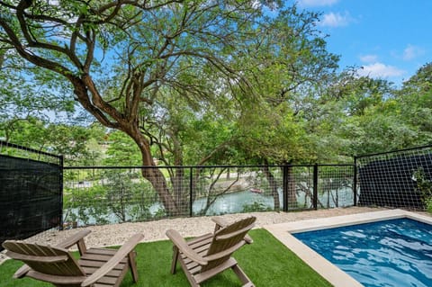 Heated pool with outdoor seating and Comal River views