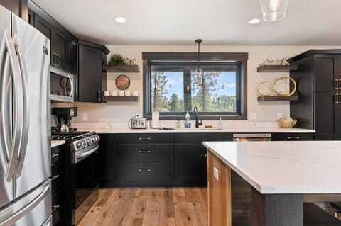 Bright kitchen window overlooking the pines of Powderhouse Pass and Deer Mountain. 