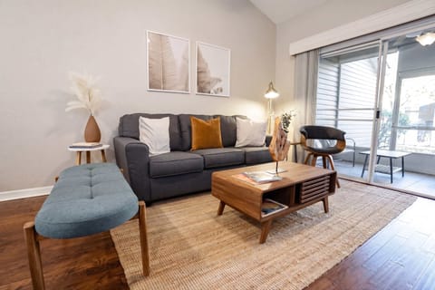 Relax in the cozy living room featuring modern decor, natural light, and direct access to the private patio.