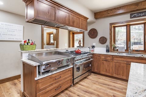 This is no run-of-the-mill kitchen! It's decked out with a commercial grade professional chef's stove and oven, and a great big grill.
