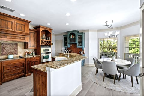 Kitchen and eating area with stocked coffee bar and stainless steal appliances.