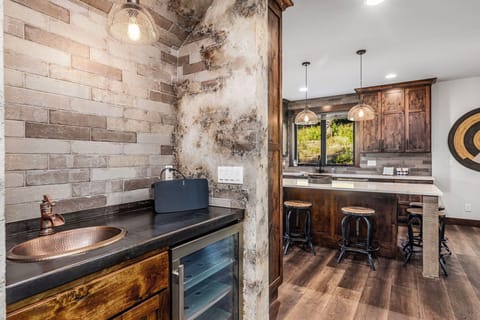 Dual Ovens And Deep Sink Anchored By Natural Wood Cabinetry