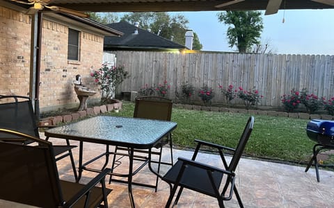 Back year with cover deck, table, chairs and grill