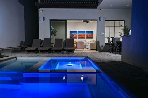 Private swimming pool with hot tub, sun shelf, and bench seating in pool.