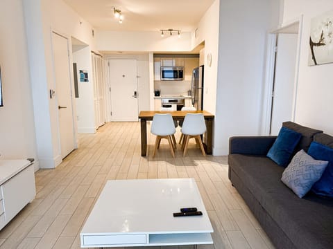 Bright living room with balcony access and city views.