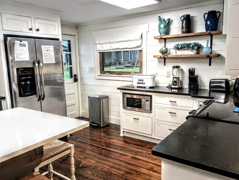 A large refrigerator and freezer, microwave, and stocked kitchen.
