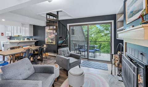 Open Living Room with Fireplace, Spiral Staircase & Deck Access
