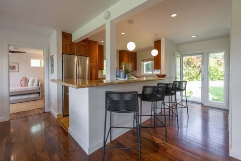 Gather around a stylish kitchen bar with granite countertops and modern high stools, perfect for casual dining and conversation.