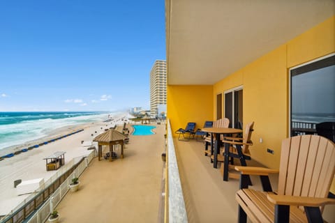 Sunny balcony w/ outdoor seating & sweeping beach views — perfect for morning coffee or evening drinks.