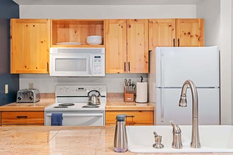 Fully equipped kitchen with brand new cookware set, knives, and coffee machine.