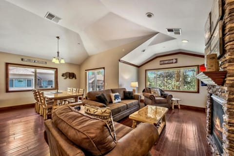 Unwind in your spacious living area with rustic charm, featuring cozy leather seating and a stone fireplace for perfect mountain evenings.