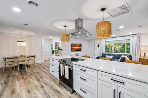Modern coastal open kitchen with stainless steel appliances and disposal.