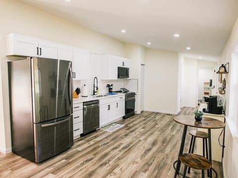 Spacious open kitchen with tiled backsplash and stainless steel appliances. Who gets to cook tonight?