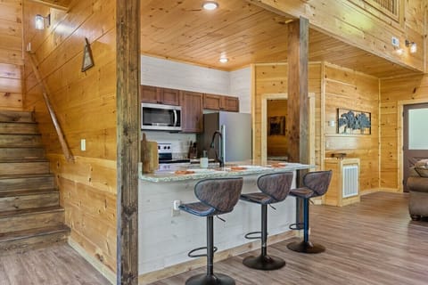 Rustic kitchen with granite countertop and seating for three in a cozy cabin setting
