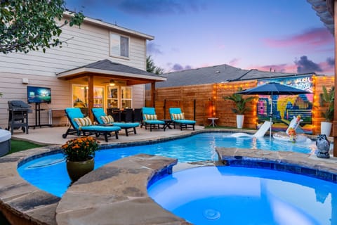 : Poolside bliss with jacuzzi, loungers, grill, and outdoor entertainment.