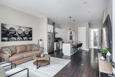 Cozy, bright lounge with wooden floors and comfortable white and brown seats.