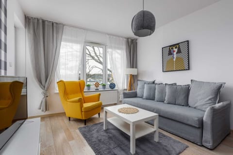 Living room with a sofa bed, TV and access to the balcony.