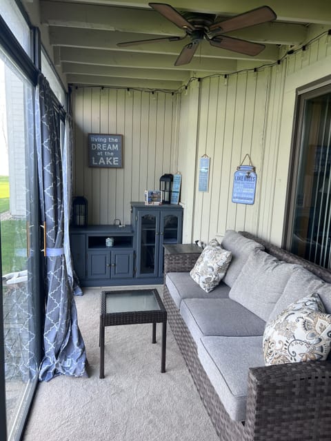 Enclosed 3 season room has comfortable couch to enjoy the lake views and sunsets