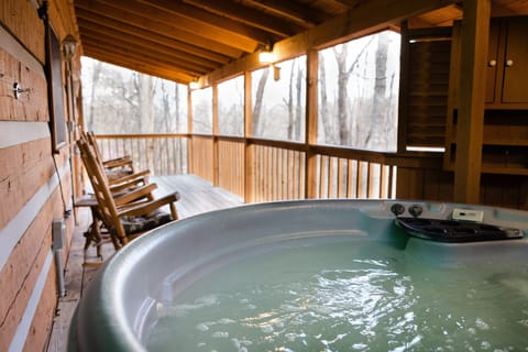 Back deck with rocking chairs and hot tub.
