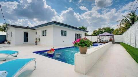 Private backyard oasis with BBQ area and outdoor seating with a large heated pool and adjoining hot tub.