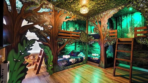 Magical forest bunk room with custom tree beds, glowing lights, and adventure feel.
