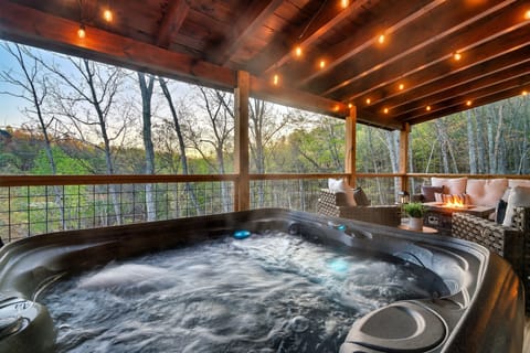 Soak in serenity on the private back deck with forrest views and twinkle lights.