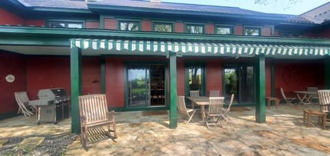 Covered back patio with outdoor seating and a view toward the pond.